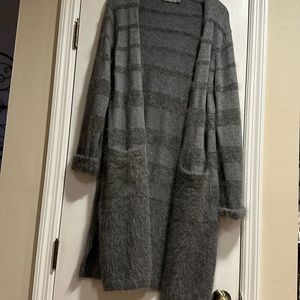 Beautiful 100% cardigan sweater with front pockets and side slits.